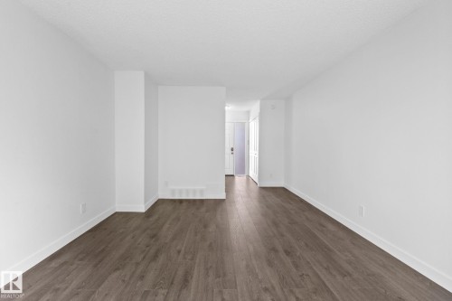 Spacious room featuring wood-finish flooring, white walls, and bright overhead lighting - 2832 135 Avenue, Edmonton, AB - Indoor Photo Showing Other Room