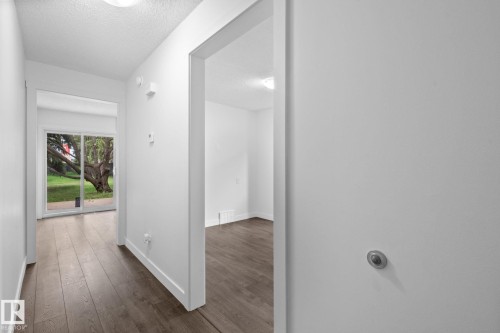 Interior hallway with wood-finish flooring and white walls - 2832 135 Avenue, Edmonton, AB - Indoor Photo Showing Other Room