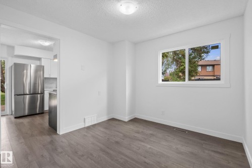 Bright interior space featuring wood-finish flooring, white walls, and a large window with white trim - 2832 135 Avenue, Edmonton, AB - Indoor