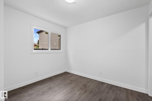 Room featuring a double-pane window, white trim, wood-finish flooring, and crisp white walls - 2832 135 Avenue, Edmonton, AB - Indoor Photo Showing Other Room