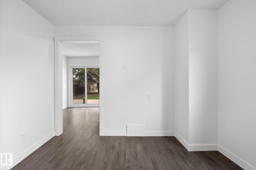 Bright interior space featuring wood-finish flooring, white walls, and white baseboards - 2832 135 Avenue, Edmonton, AB - Indoor Photo Showing Other Room