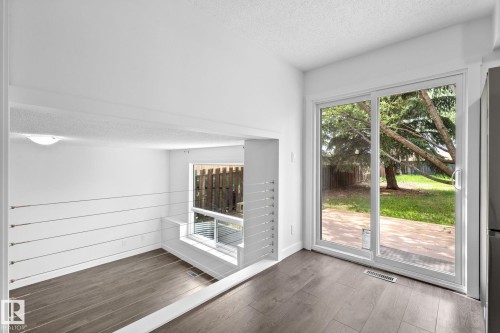 Patio door with yard access, wood-finish flooring, white walls, and contemporary cable railing - 2832 135 Avenue, Edmonton, AB - Indoor Photo Showing Other Room