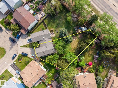 Aerial perspective showcasing a property with a distinctive L-shaped roofline, an expansive green space, mature trees, and a paved driveway - 2832 135 Avenue, Edmonton, AB - Outdoor With View