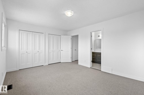 Spacious room featuring neutral carpeting, white walls, and bright white trim - 2832 135 Avenue, Edmonton, AB - Indoor