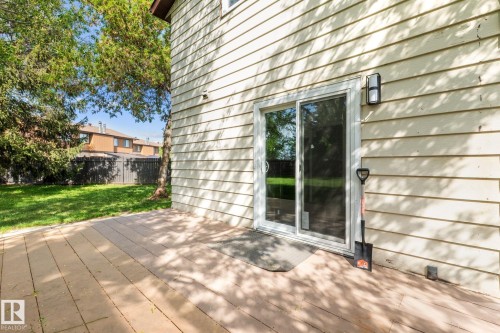 Exterior siding with sliding glass door access to a paver patio and a surrounding lawn area - 2832 135 Avenue, Edmonton, AB - Outdoor