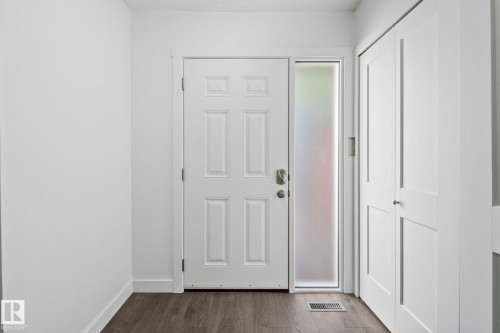 Entryway with a paneled door, frosted sidelight, and wood-finish flooring - 2832 135 Avenue, Edmonton, AB - Indoor Photo Showing Other Room