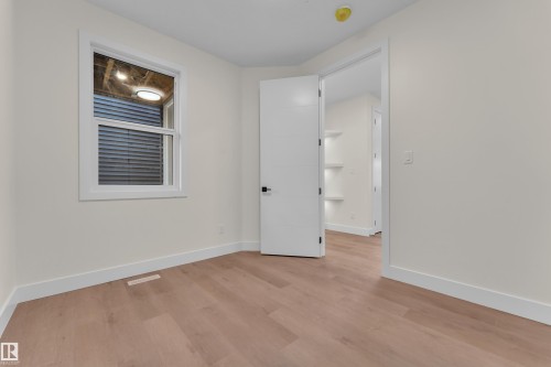 Room featuring light wood-finish flooring, white baseboards, and a white framed window - 3602 44 Avenue, Beaumont, AB 
