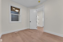 Room featuring light wood-finish flooring, white baseboards, and a white framed window - 