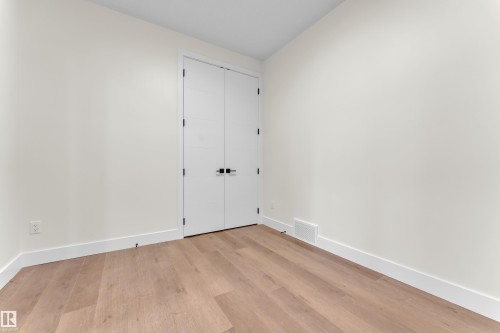 Interior room featuring a wood-finish floor, white baseboards, and light-toned walls - 3602 44 Avenue, Beaumont, AB 