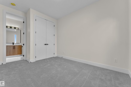 Plush gray carpeting and white baseboards define this room, featuring a double-door closet with black hardware - 3602 44 Avenue, Beaumont, AB 