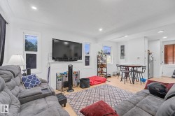 Open-concept living area featuring light wood-finish flooring, recessed lighting, and white walls - 