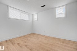 Bright room featuring wood-finish flooring, crisp white walls, and white trim - 