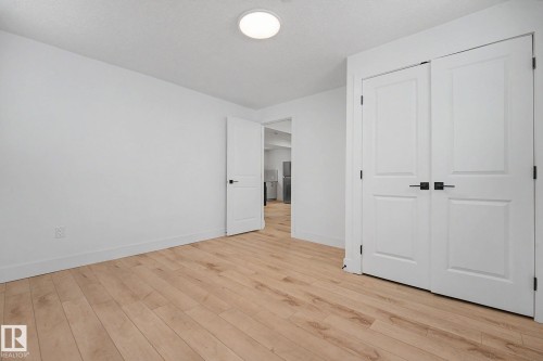 Room featuring light wood-finish flooring and white walls - 11914 124 Street, Edmonton, AB 