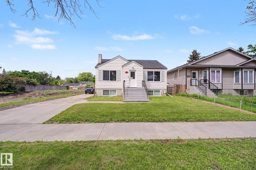 Traditional single-story residence featuring light-colored siding, a dark shingled roof, and a prominent front entrance with a porch and steps - 11914 124 Street, Edmonton, AB 