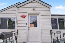 Cream-colored siding exterior featuring a white paneled entry door with a glass insert - 