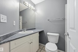 Bathroom featuring a vanity with an integrated sink, a speckled countertop, and white cabinetry with chrome hardware - 