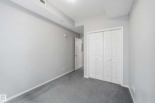 Room featuring light gray walls and gray carpeting - 203 11103 84 Avenue, Edmonton, AB 