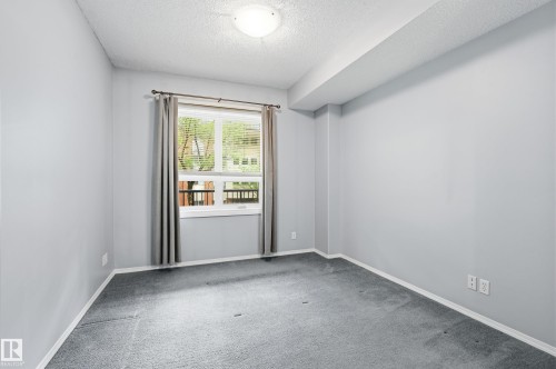 Neutral-toned carpeting paired with light gray walls and white trim - 203 11103 84 Avenue, Edmonton, AB 