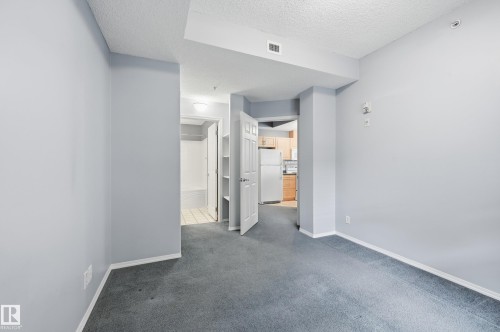 Carpeted room with light gray walls, white baseboards, and white ceiling - 203 11103 84 Avenue, Edmonton, AB 