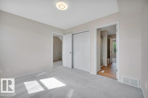 Carpeted room with neutral wall tones and a flush-mount ceiling light fixture - 14 4367 Veterans Way, Edmonton, AB 