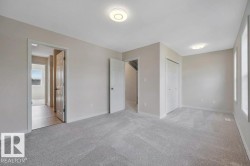 Spacious room featuring light gray carpeting, neutral-toned walls, and recessed lighting - 