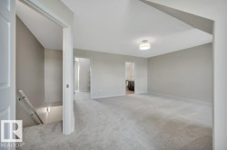 Expansive carpeted room featuring neutral wall tones and a flush-mount ceiling light fixture - 