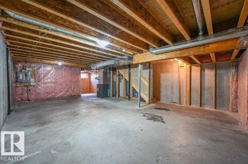 Unfinished basement featuring exposed wood joists, concrete flooring, and visible insulation - 14 4367 Veterans Way, Edmonton, AB 