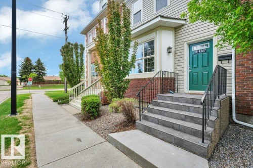 Multi-level entryway with tile stairs and wrought iron railings - 14 4367 Veterans Way, Edmonton, AB 