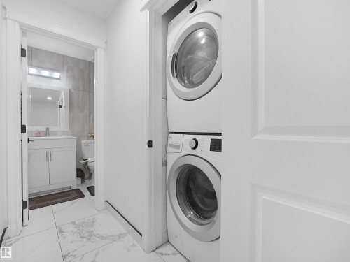 Laundry closet featuring a stacked washer and dryer unit - 2418 32B Street, Edmonton, AB 