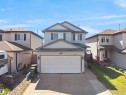 Two-story residence featuring light-colored siding and a two-car attached garage with a concrete driveway - 2418 32B Street, Edmonton, AB 