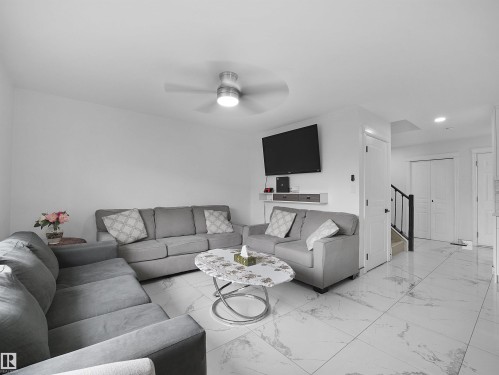 Bright living area featuring white walls and a contemporary ceiling fan with integrated lighting - 2418 32B Street, Edmonton, AB 
