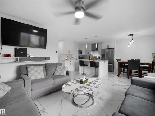 Open-concept living space featuring large format white tile flooring with subtle veining - 2418 32B Street, Edmonton, AB 