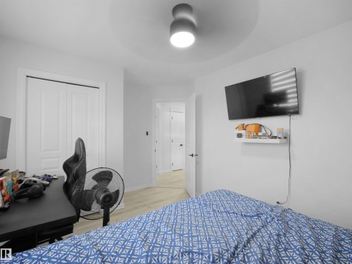 Interior room featuring light-colored wood-finish flooring, white walls, and a modern ceiling light fixture - 2418 32B Street, Edmonton, AB 