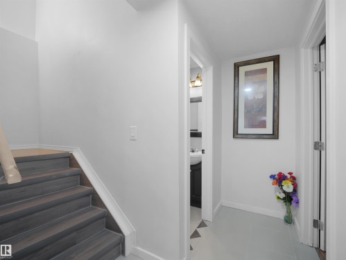 Wood-finish stairs with white risers and trim - 2418 32B Street, Edmonton, AB 