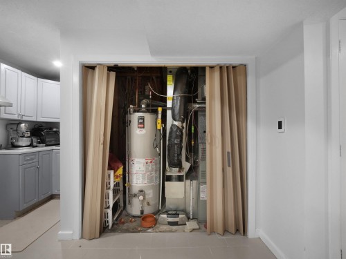 Utility closet with a water heater and furnace, featuring bi-fold doors - 2418 32B Street, Edmonton, AB 