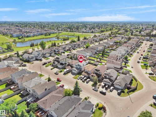 Suburban neighborhood featuring a landscaped retention pond with surrounding green spaces - 2418 32B Street, Edmonton, AB 
