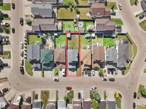 Aerial view showcasing a residential property with a detached home, paved driveway, and a fenced backyard - 2418 32B Street, Edmonton, AB 