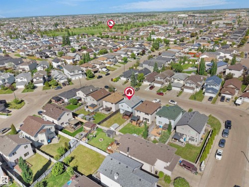 Aerial view of a residential neighborhood featuring detached homes with varied architectural styles and rooflines, established landscaping, and paved streets - 2418 32B Street, Edmonton, AB 