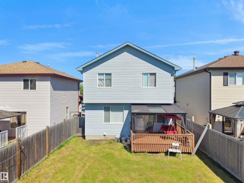 Rear exterior featuring light blue siding and a brown wood deck - 2418 32B Street, Edmonton, AB 