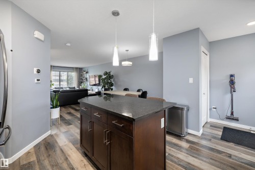 Kitchen island featuring a dark wood-finish base with cabinet storage and a dark countertop - 2833 Chokecherry Place, Edmonton, AB 