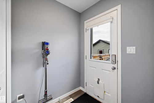 Entry door with integrated window, featuring a smart lock and privacy blind - 2833 Chokecherry Place, Edmonton, AB 
