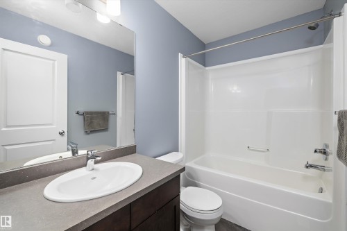 Bathroom featuring a vanity with an oval undermount sink, a gray countertop, and dark wood-finish cabinetry - 2833 Chokecherry Place, Edmonton, AB 