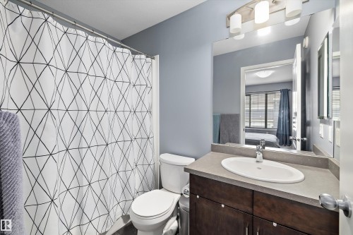 Bathroom featuring a dark wood-finish vanity with a light countertop, an oval undermount sink, and a chrome faucet - 2833 Chokecherry Place, Edmonton, AB 
