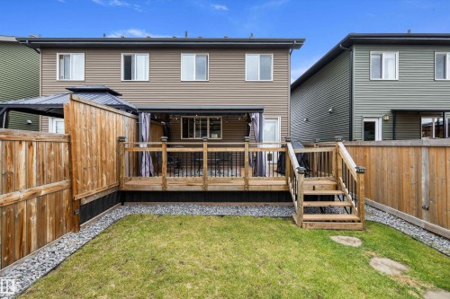 Expansive backyard featuring a manicured lawn and a spacious wood deck with railing - 2833 Chokecherry Place, Edmonton, AB 