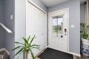 Entryway featuring a paneled door with integrated window, bi-fold closet doors, and wood-finish flooring - 2833 Chokecherry Place, Edmonton, AB 