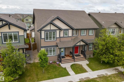 Contemporary two-story duplex featuring complementary siding colors and dark trim accents - 2833 Chokecherry Place, Edmonton, AB 