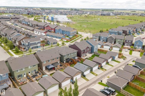 Residential streetscape featuring a variety of detached homes with attached garages, individual fenced yards, and paved driveways - 2833 Chokecherry Place, Edmonton, AB 
