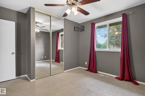 Room featuring light-colored carpet flooring, a ceiling fan with integrated lighting, and a window providing natural illumination - 13427 114 Street, Edmonton, AB 
