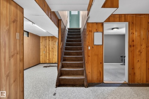 Staircase with carpeted treads and wood-paneled walls - 13427 114 Street, Edmonton, AB 