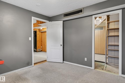 Carpeted room with gray walls and a textured white ceiling - 13427 114 Street, Edmonton, AB 